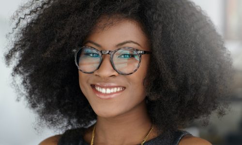 Portrait of a smiling business woman with an afro in bright glass office